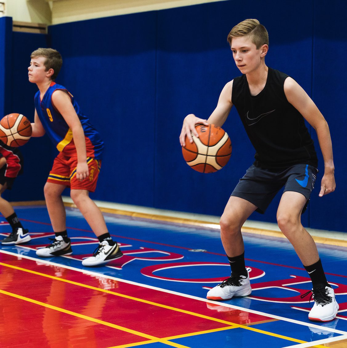 Boy dribbling basketball at holiday skills clinic